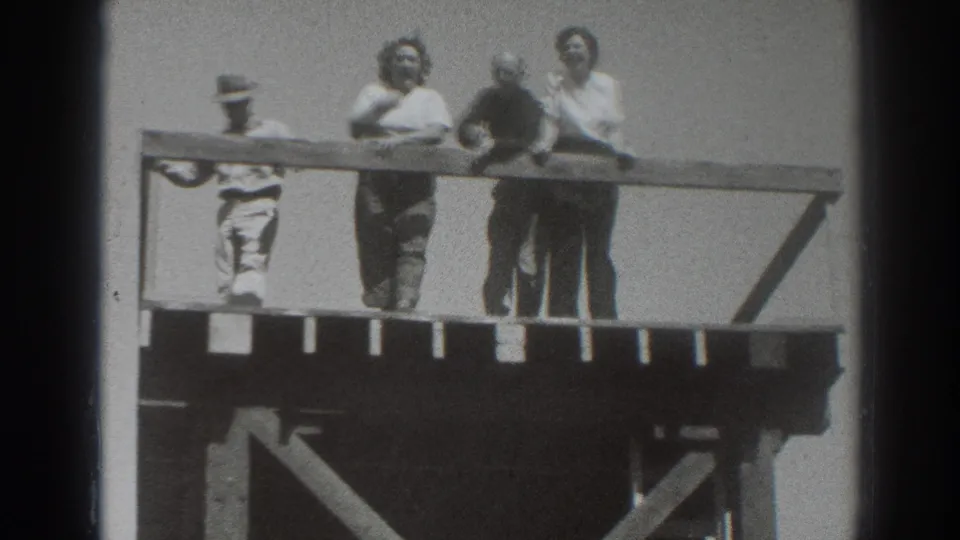 Four adults on the Sacramento overlook platform face the camera and railing, with one hat-wearing figure at the left edge.
