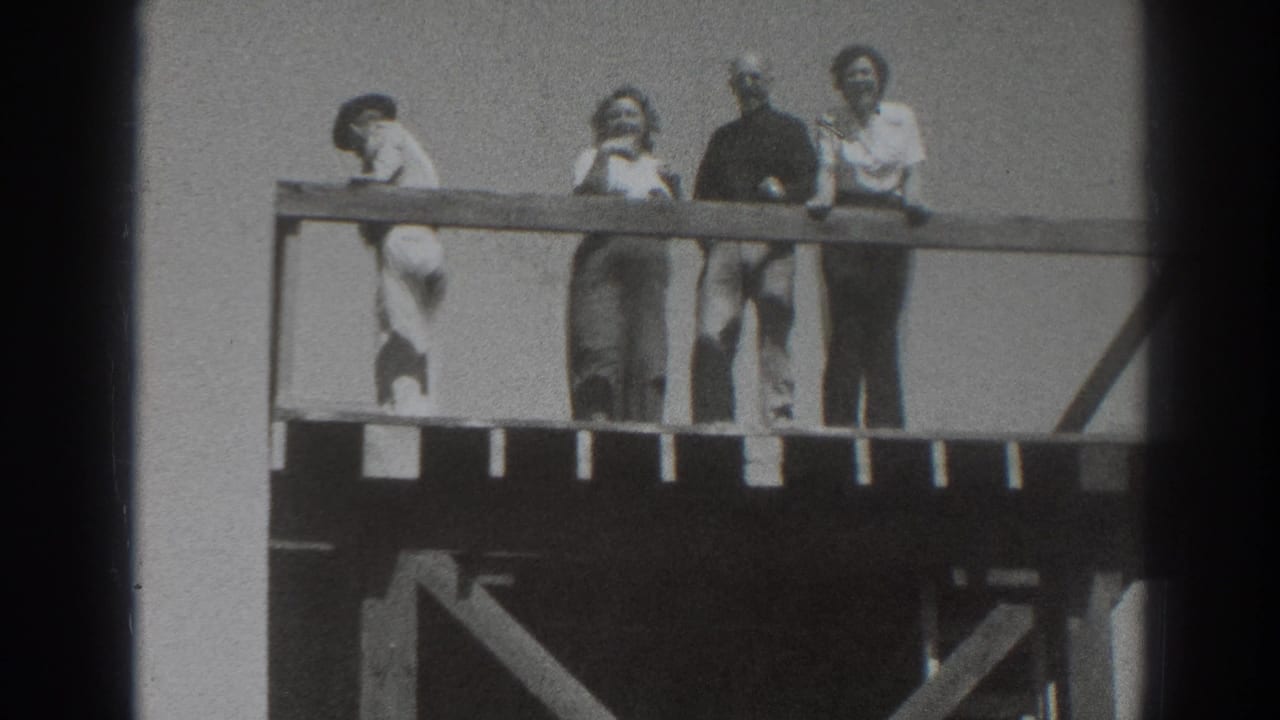 Four adults appear along a wooden deck railing in Sacramento, with one person bent forward and others watching or smiling.