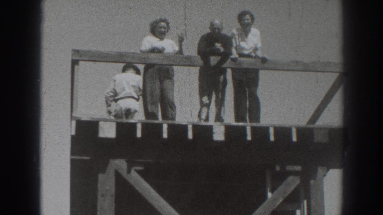 Adults on an elevated wooden deck in 1937 Sacramento face the camera while another figure crouches or bends near the rail.