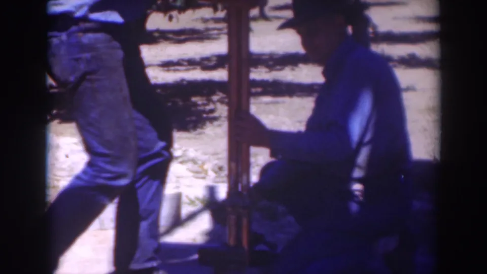 At the end of the 1937 Sacramento clip, one man is partly cropped while another crouches near the upright post in deep shade.