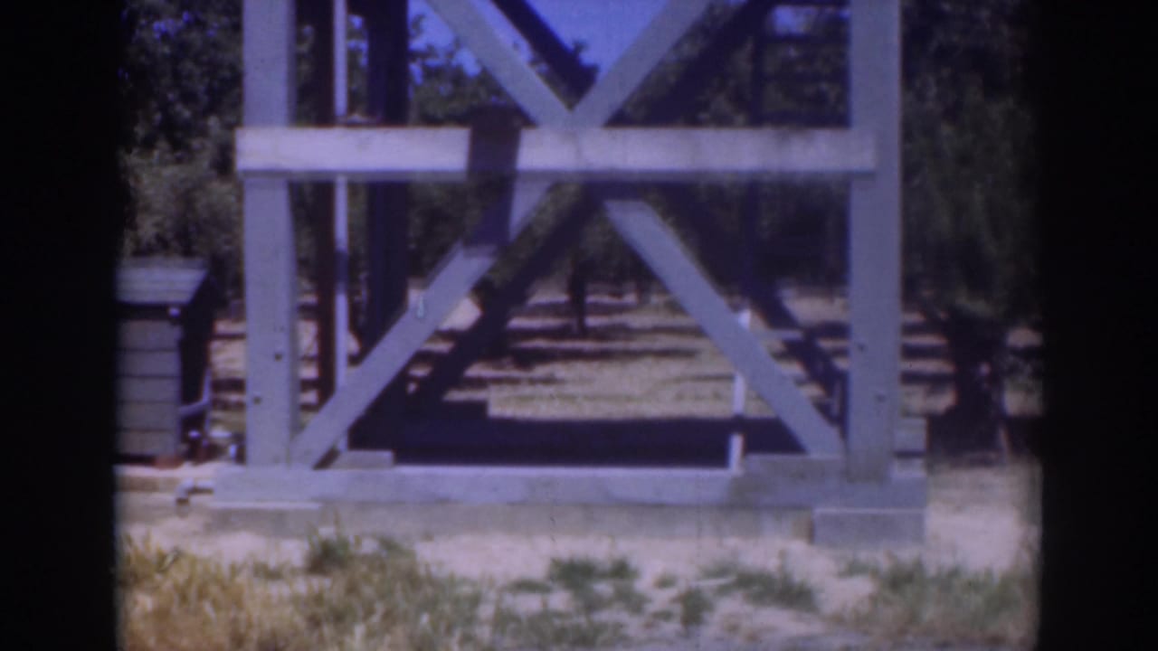 The 1937 Sacramento home-movie frame centers on the wooden structure after the man has moved out of view.