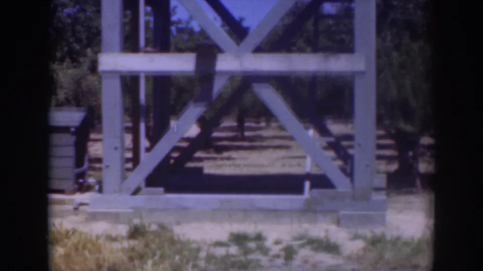 The 1937 Sacramento home-movie frame centers on the wooden structure after the man has moved out of view.