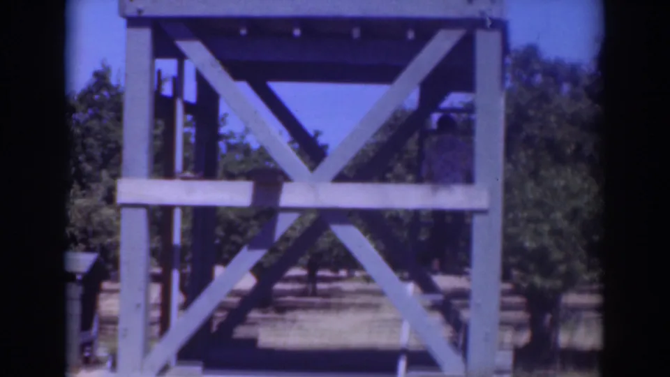 1937 Sacramento frame focused on the blue X-braced tower, with the climbing man mostly hidden at the edge.