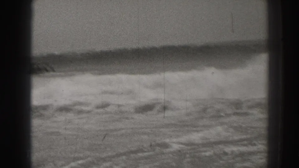 Vintage Santa Cruz shoreline frame with a rolling wave in front and two sea stacks near the horizon.