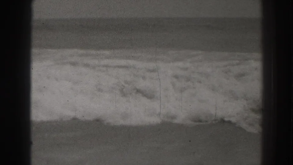 The 1937 Santa Cruz shoreline appears with foamy water washing across the lower frame and a muted ocean horizon beyond.