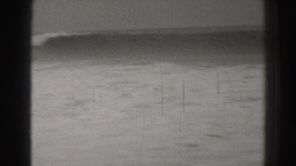 1937 home-movie view of layered Santa Cruz surf, with a dark swell in the foreground and foam beyond.