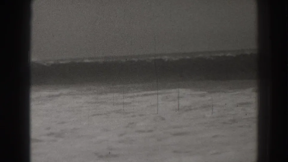 Santa Cruz 1937 8mm frame showing a long dark wave face with foamy water along the beach.