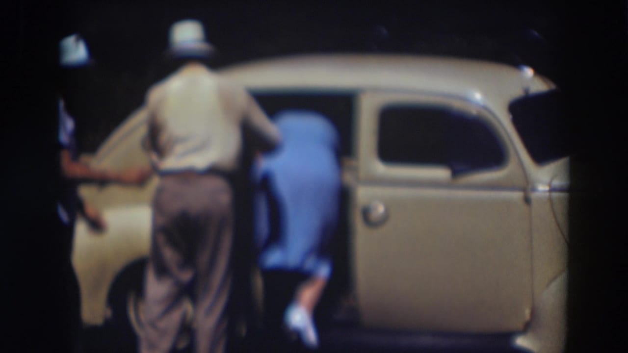 Near the end of the 1937 Truckee clip, the woman steps into the rear seat of the cream sedan as the man stands just behind her.