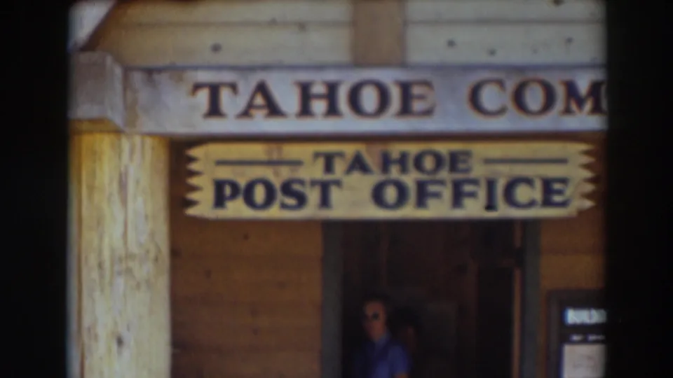 Soft 8mm frame of the Tahoe Post Office exterior in Truckee, with wood walls, sign lettering, and a person partly visible below.