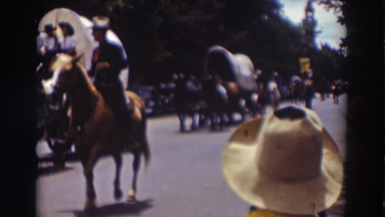 Truckee parade footage from 1937 shows a rider in Western dress near covered wagons, with a large spectator hat at the lower right.