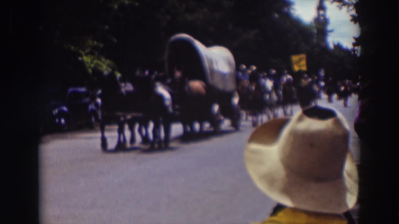The covered wagon procession continues in the 1937 Truckee parade scene, with horses, onlookers, cars, and a foreground hat visible.