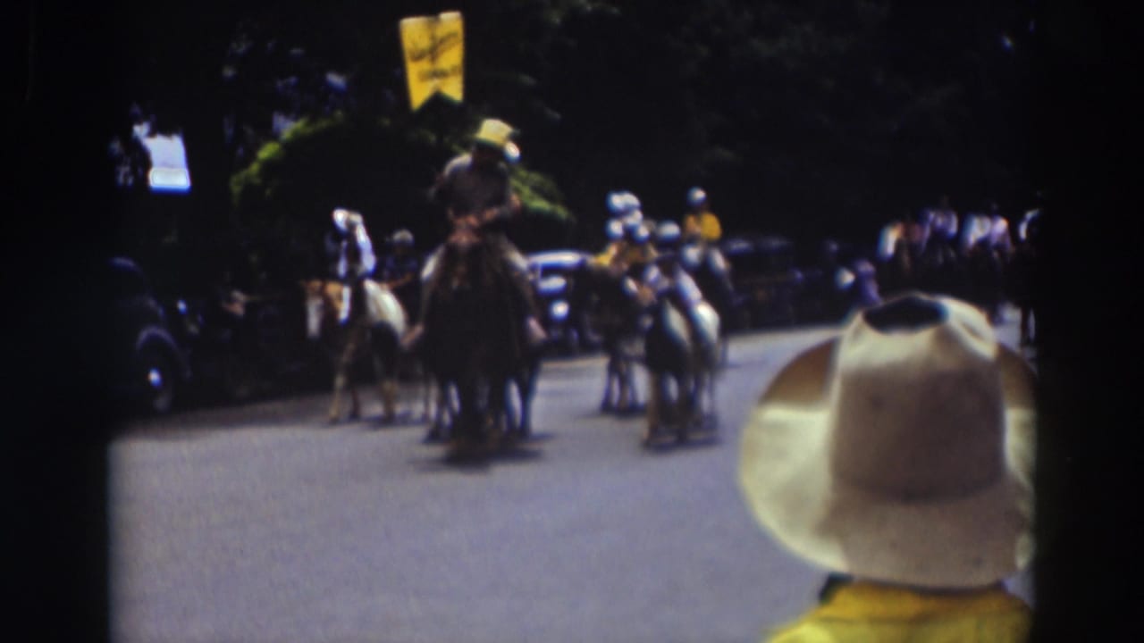 In the 1937 Truckee parade, a rider carrying a yellow flag appears near the front of a group of mounted participants.