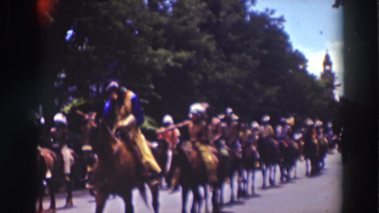 Costumed riders on horseback move along a tree-lined road with spectators nearby.