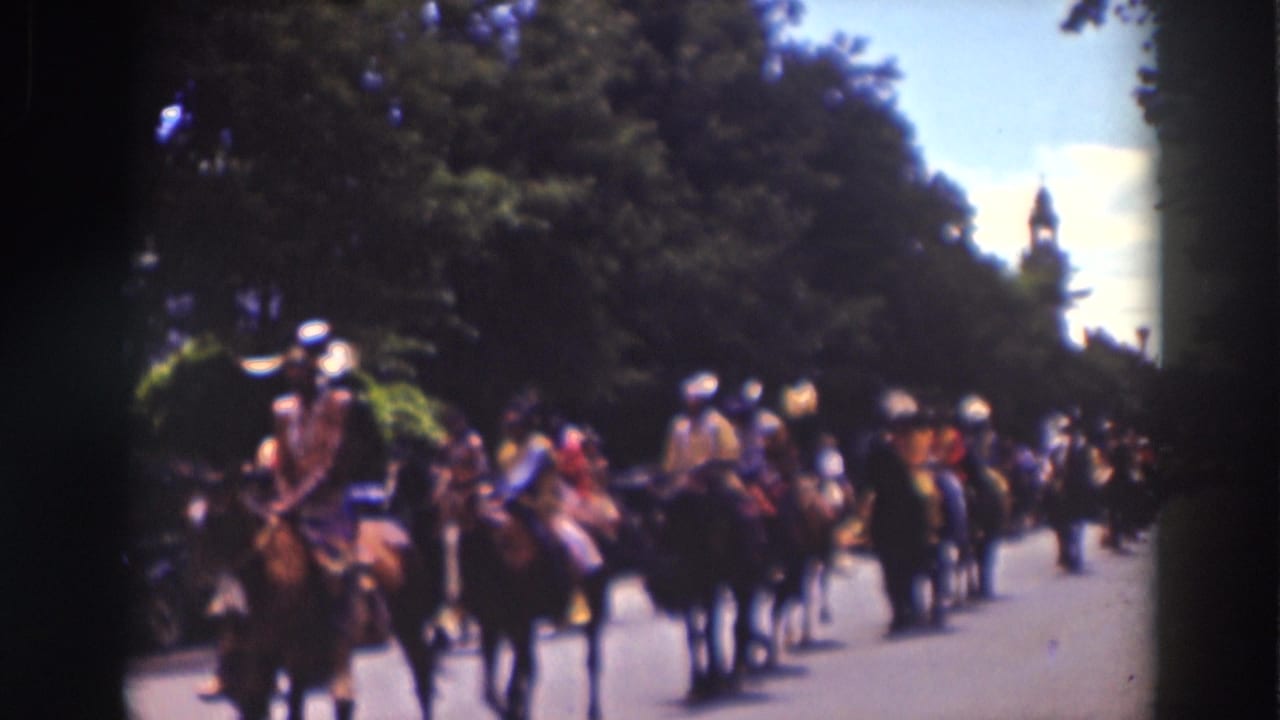 The horseback parade line stretches down the tree-lined Truckee road, with riders and spectators visible in soft 8mm color.