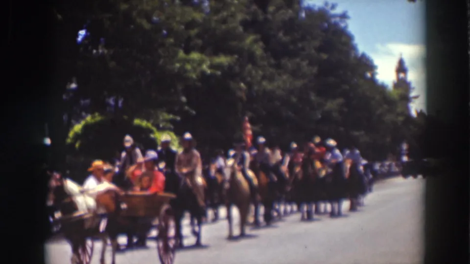 1937 Truckee parade scene with mounted riders, a horse-drawn carriage, flags, and spectators along a sunlit street.