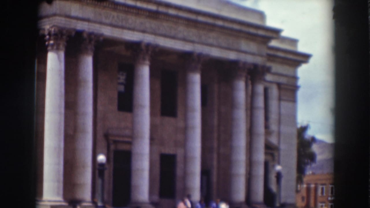 Courthouse columns and entrance with pedestrians at the base of the building.