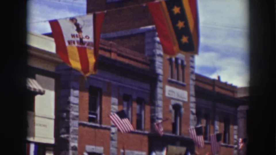 Truckee, California building front in 1937 with American flags, a visible "HELLO NEW HAMPSHIRE" banner, and period storefront details.