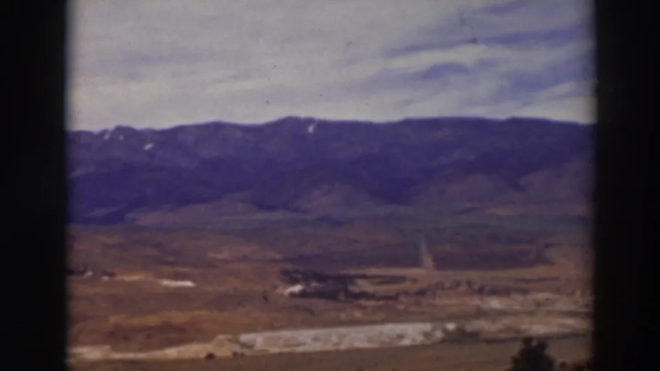 Truckee-area 1937 landscape view with arid ground, a pale winding feature, and distant mountains with faint snow patches.