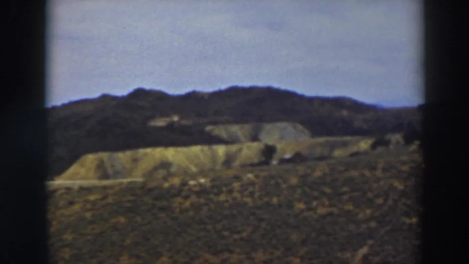 1937 8mm home-movie view of rolling hills near Truckee, California, with dry grassland and a dark distant ridge.