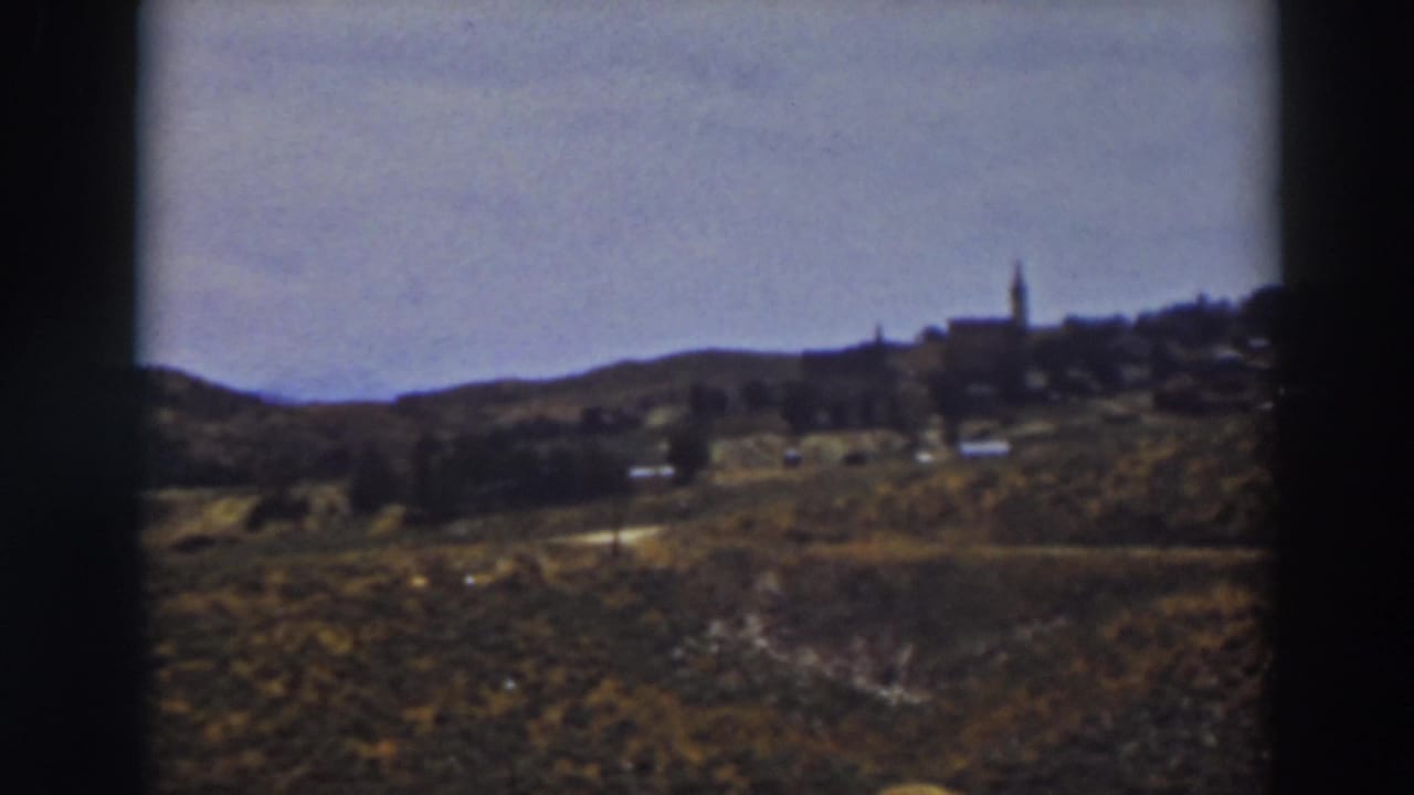 A soft 8mm view across the Truckee countryside toward a small ridge settlement and prominent steeple.