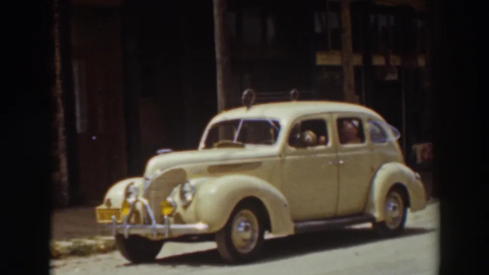 Cream-colored vintage automobile in Truckee, California, viewed from the front side with chrome trim and roof rack visible.