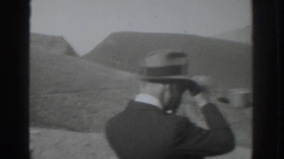 A suited man in a fedora appears to take a photograph across the rural valley in the supplied 1937 Vacaville home movie.