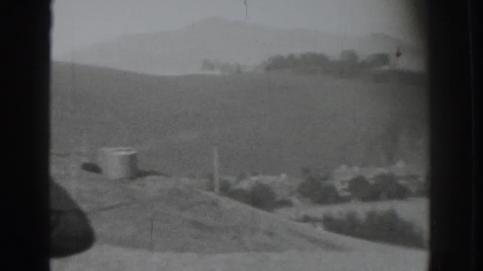 A soft black-and-white view shows the rural hillside overlook and distant tree line in the supplied Vacaville home-movie clip.