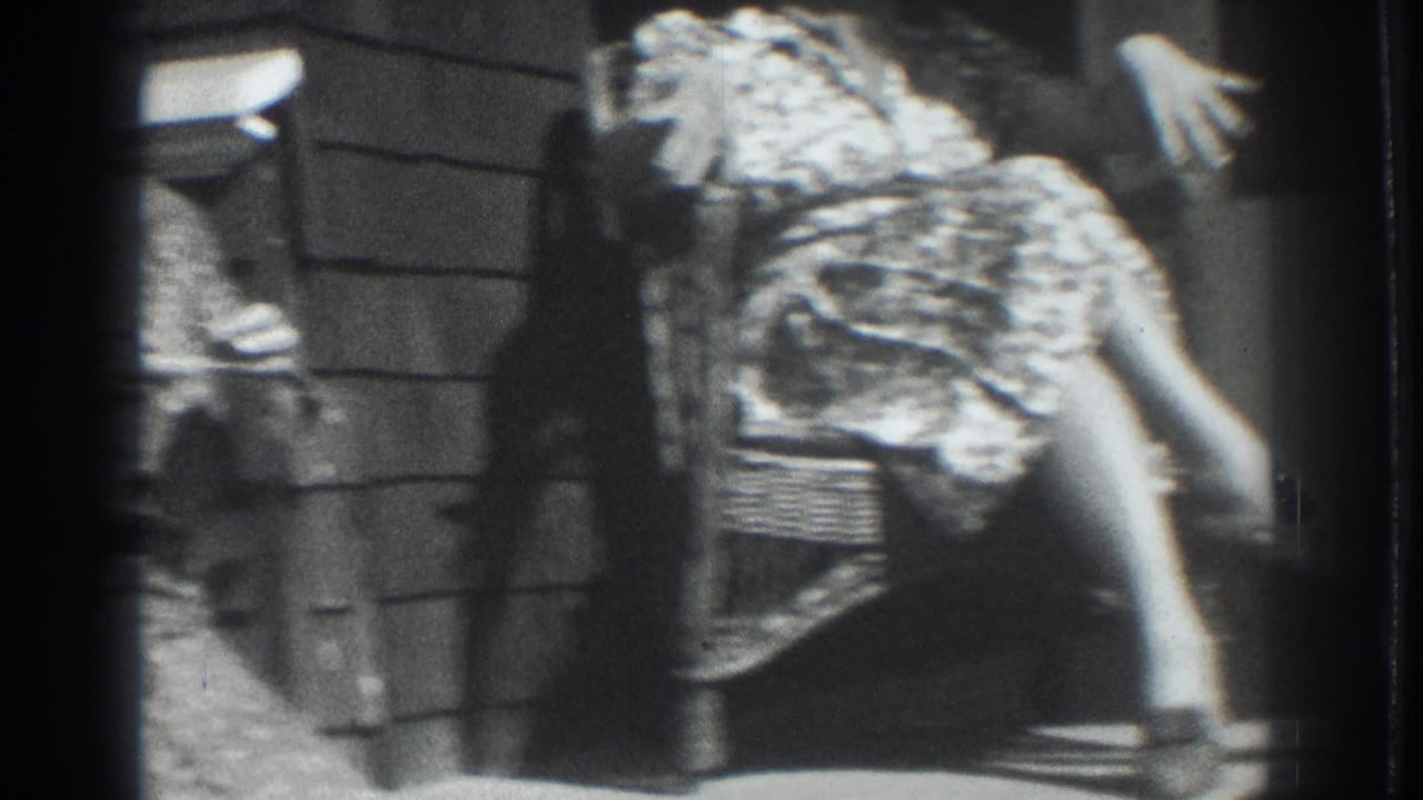 Vacaville, California 1937 home-movie frame showing adult women in patterned dresses seated on a porch, with wicker furniture and strong sunlight.