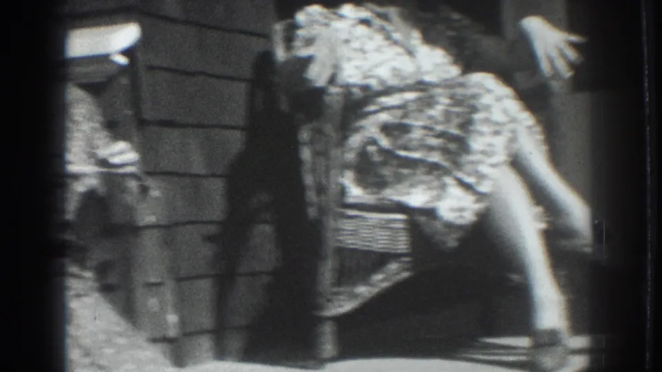 Vacaville, California 1937 home-movie frame showing adult women in patterned dresses seated on a porch, with wicker furniture and strong sunlight.