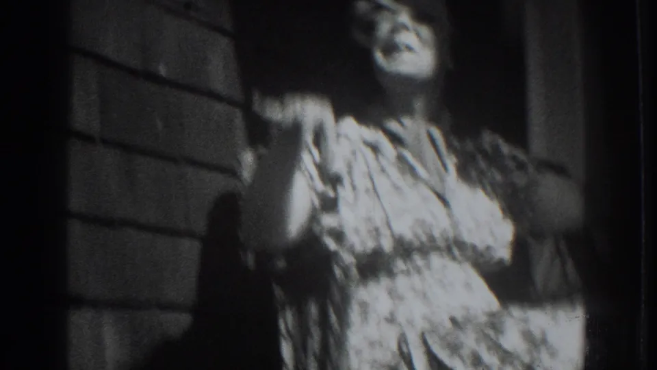 A closer 8mm frame shows a woman in a patterned dress raising her hand on a porch in 1937 Vacaville footage.