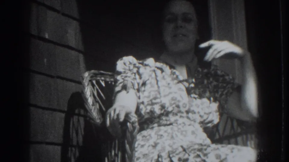 A 1937 Vacaville frame shows the woman seated on the porch, lifting one hand near her face while looking toward the camera.