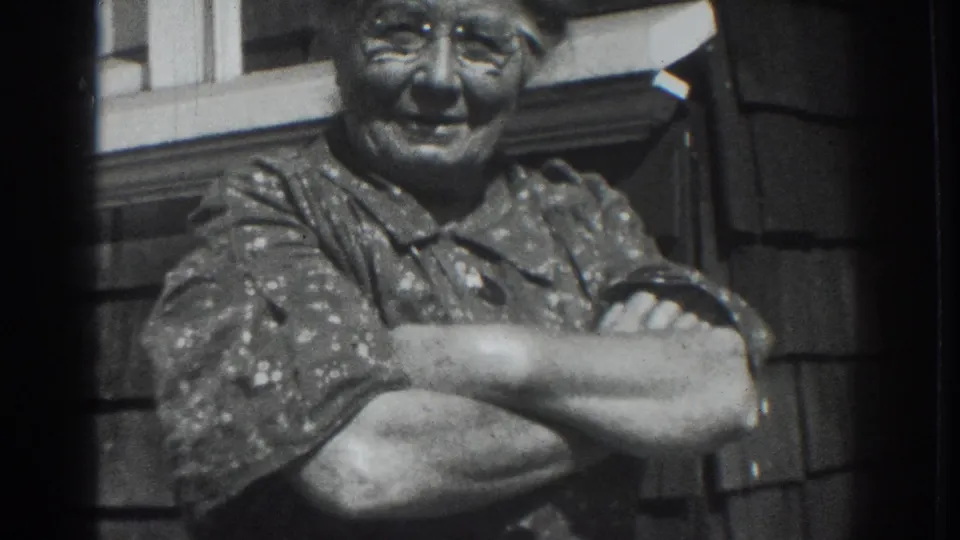 Older woman in Vacaville, California, stands close to the camera with folded arms in black-and-white 8mm footage.