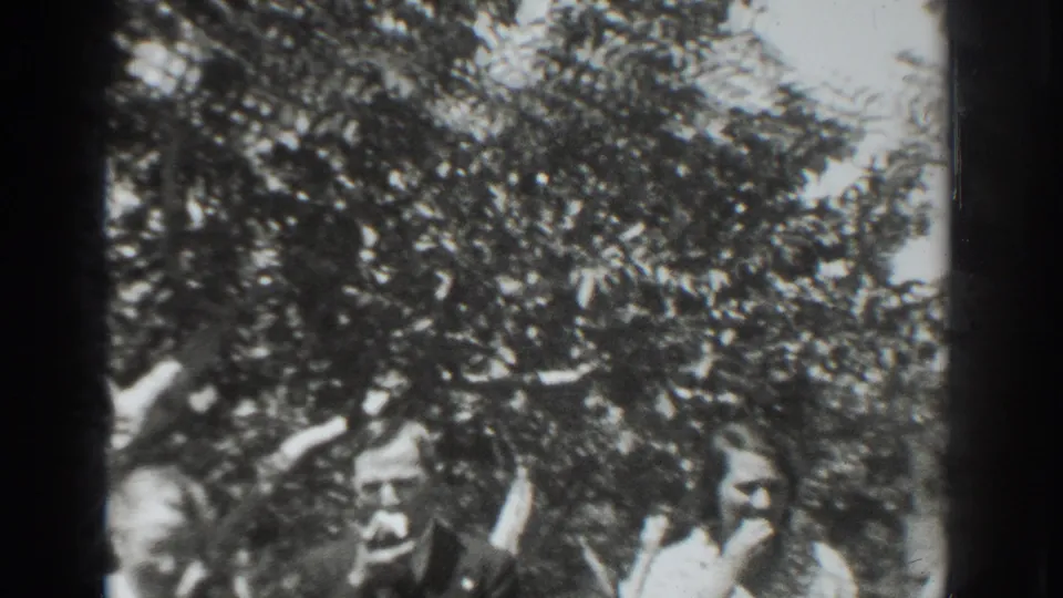Family members in 1937 Vacaville stand near the camera beneath orchard trees, with one person appearing to eat or hold fruit.