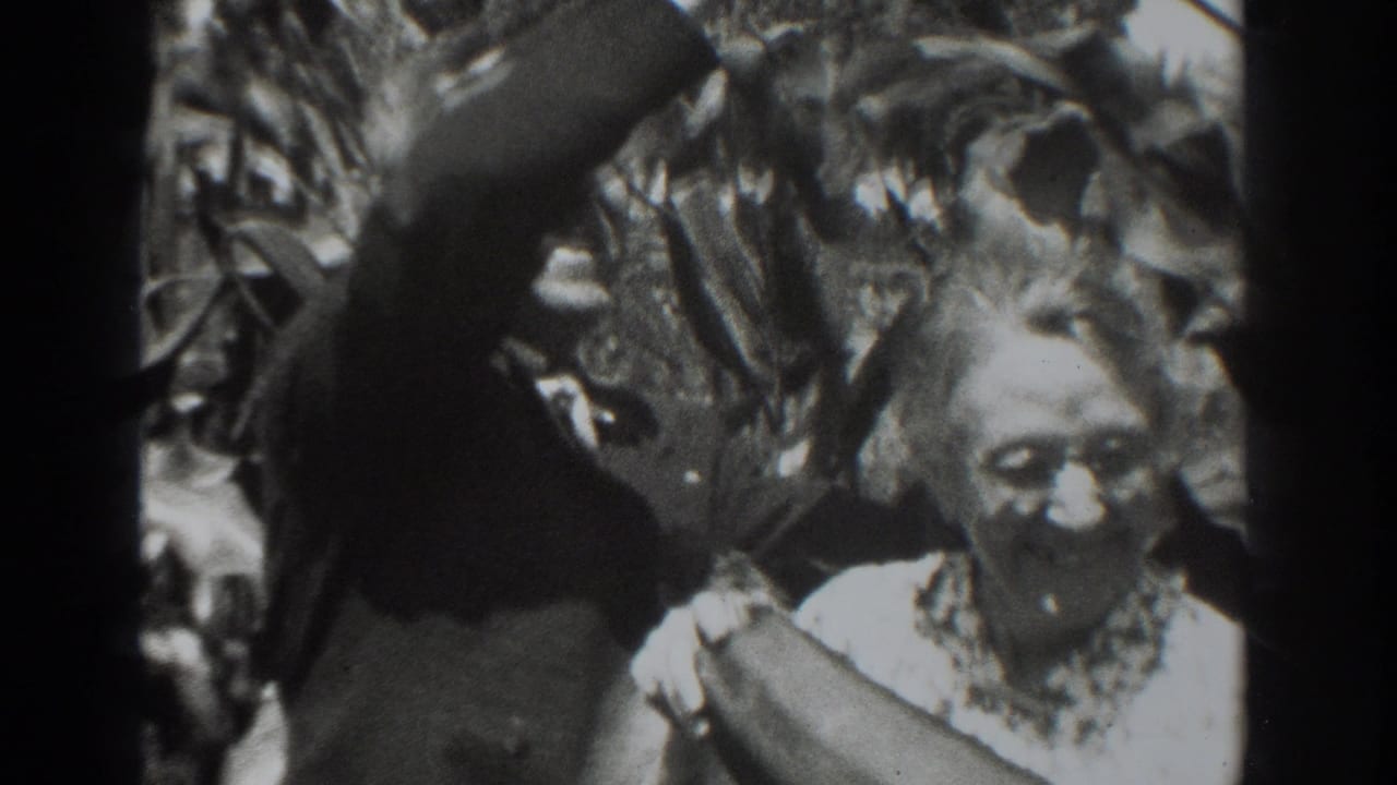 In the 1937 Vacaville home-movie scene, an older woman and a man stand amid tall garden growth with oversized produce.