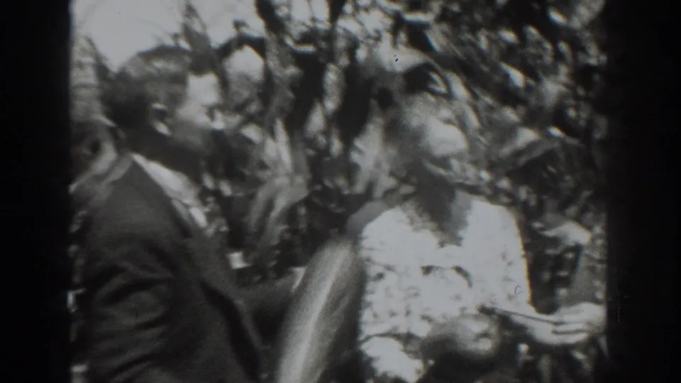 In Vacaville, California in 1937, a suited man and a woman in a light dress appear to examine harvested produce near tall stalks.