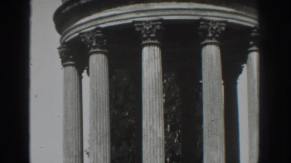 Black-and-white 8mm frame from Vacaville showing a rounded classical monument top above tall Roman-style columns.