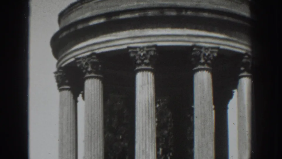 1937 8mm frame emphasizing the monument's curved upper band, carved capitals, and vertical fluted columns.