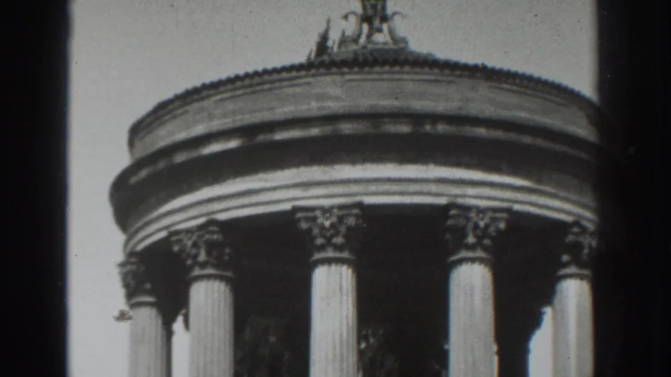 1937 Vacaville home-movie frame showing the upper rotunda, columns, rounded roofline, and decorative finial against a bright sky.