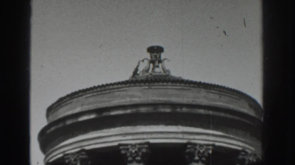 1937 Vacaville frame with the camera tilted toward the dome edge, finial, and upper columns of a classical rotunda.