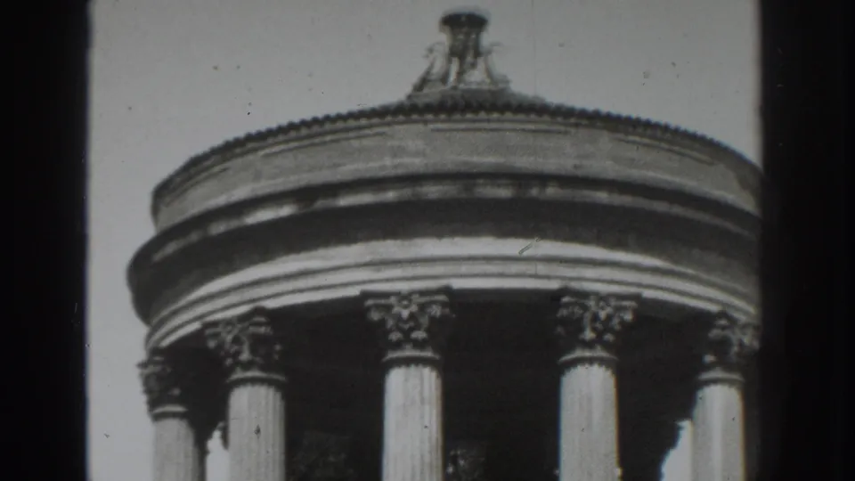 Black-and-white 8mm frame from Vacaville showing a rounded cornice, column capitals, and the top of a classical structure.