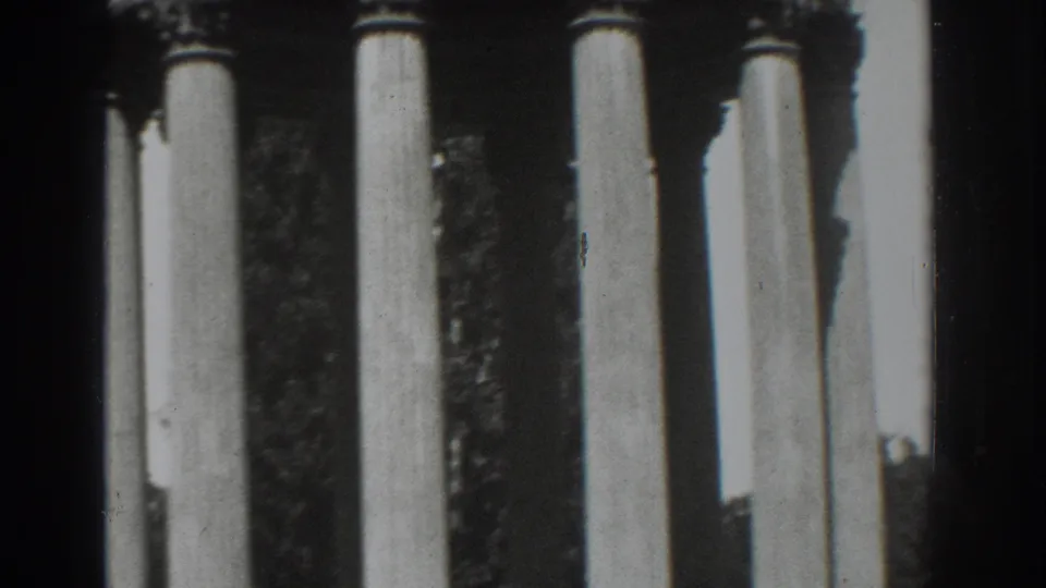 1937 Vacaville frame showing the five-column classical structure, decorative capitals, and tree shadows behind it.