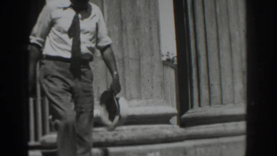 The man is lower on the steps, walking past large stone columns in the 1937 Vacaville home-movie scene.