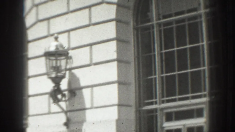 1937 Vacaville exterior view of a stone civic facade with tall gridded windows and a wall-mounted lantern.