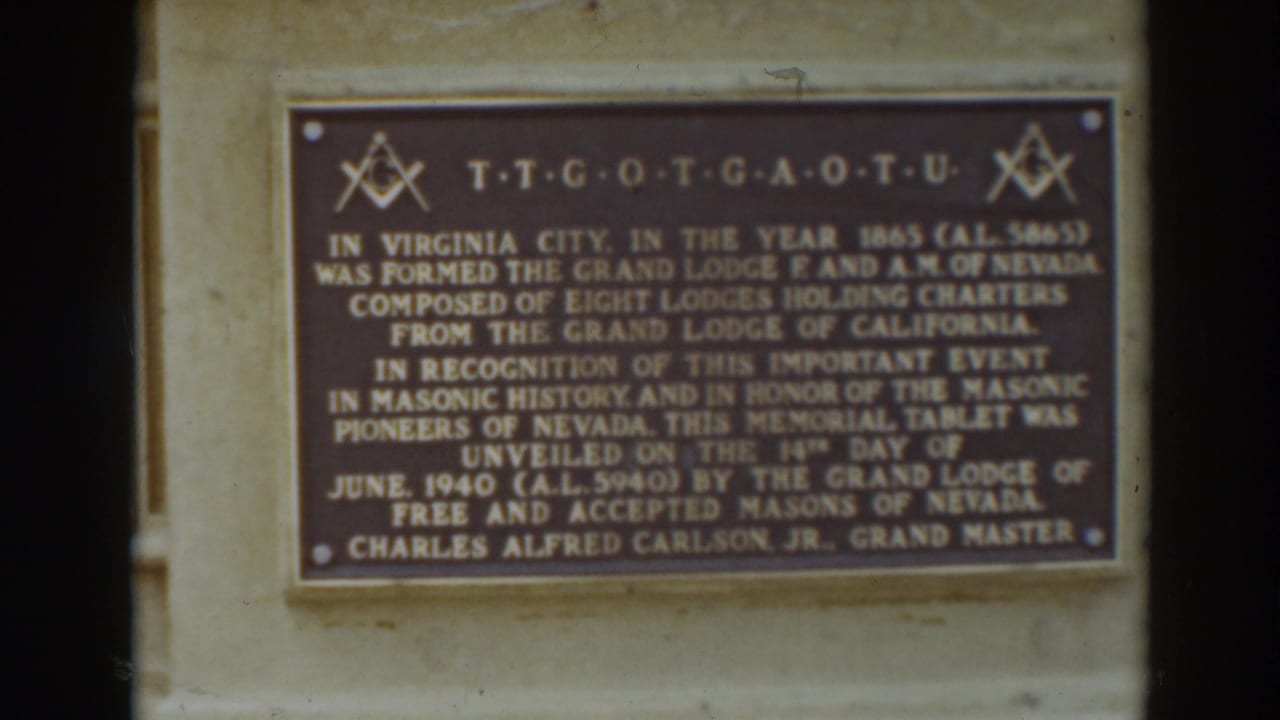 Close 8mm frame of a Masonic commemorative plaque on a light stone wall in Virginia City, as identified by clip metadata.