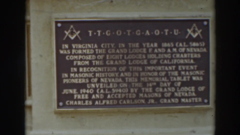 Visitor-shot close-up of the commemorative Masonic plaque, with the inscription and symbols visible in a soft 8mm frame.
