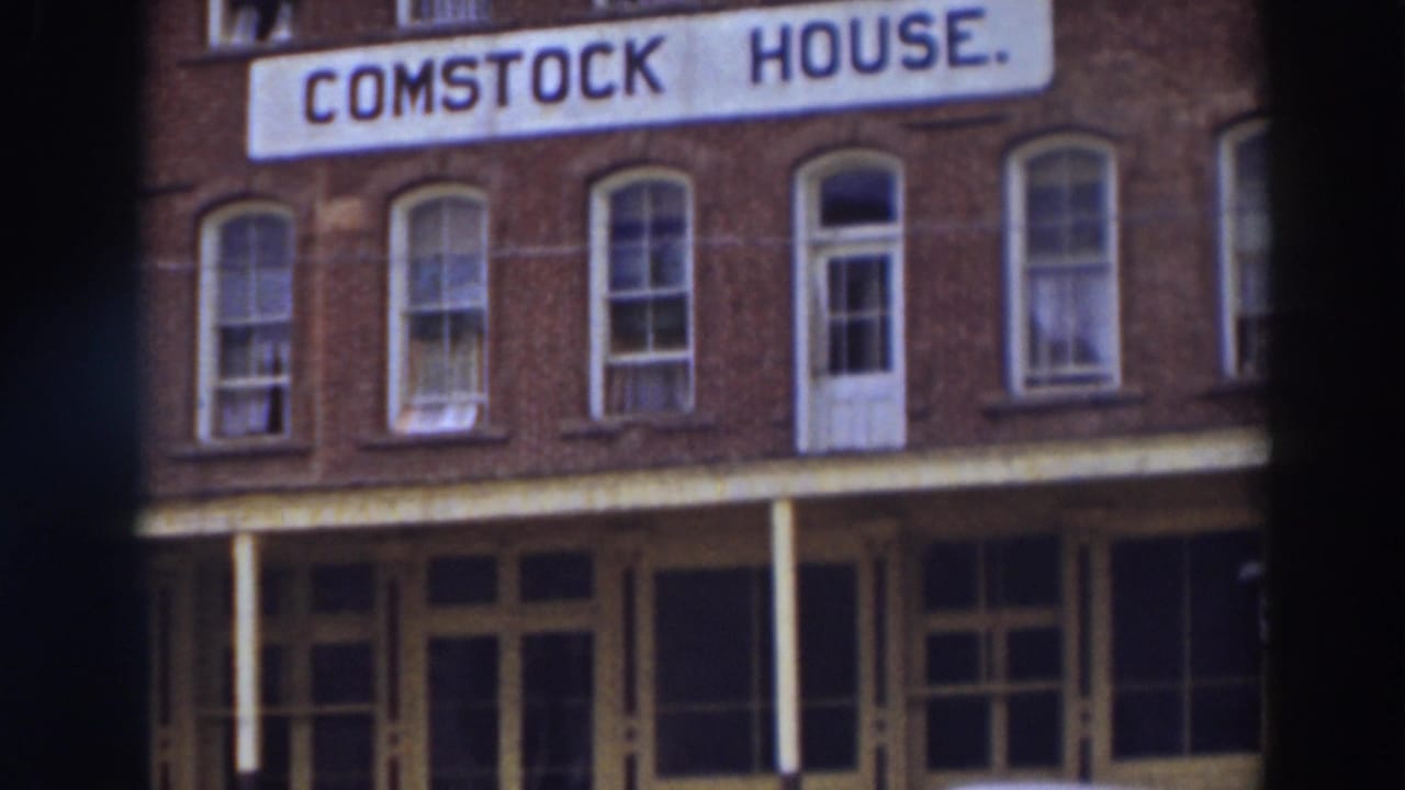 Comstock House sign on a red brick building with arched windows and porch trim.
