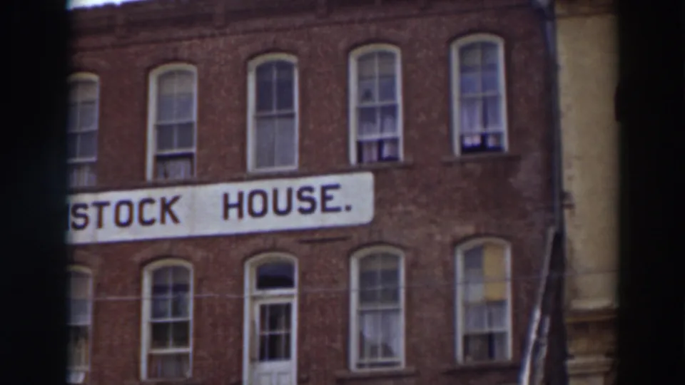 The final frame holds on the cropped Comstock House sign beneath rows of windows on the red brick facade in Virginia City, California.