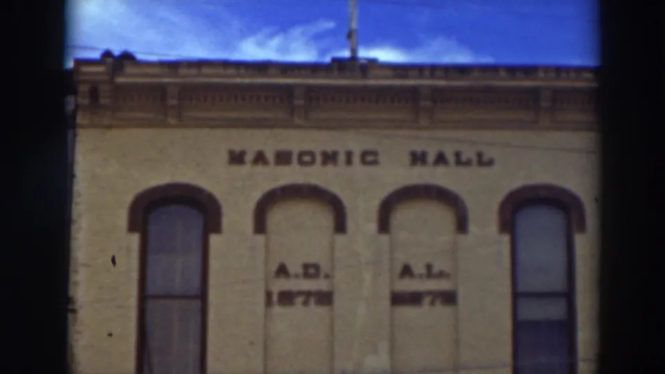 Home-movie frame of the Masonic Hall facade in Virginia City, California, centered on its upper windows and lettering.