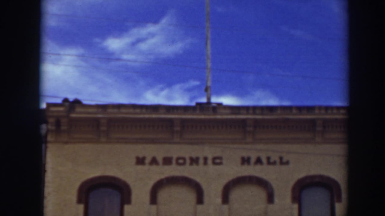 Masonic Hall facade with arched windows under a blue sky.