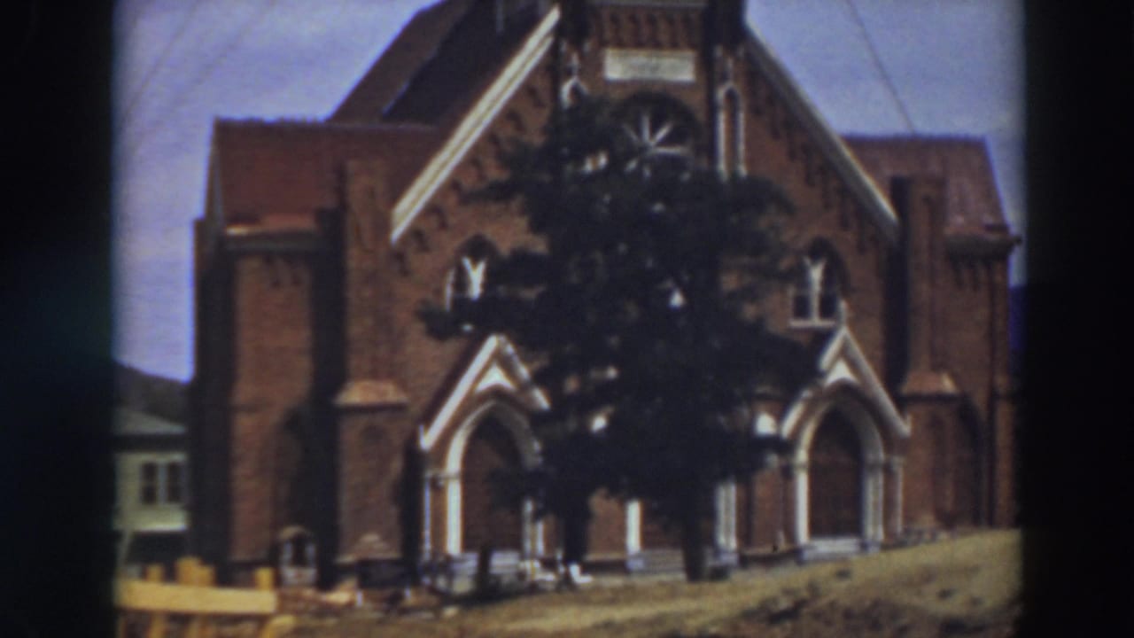 Similar church facade view with tree shadowing the central brickwork.
